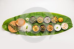 South IndianÂ style lunch or dinner meal or food served with a selection of recipes over banana leaf